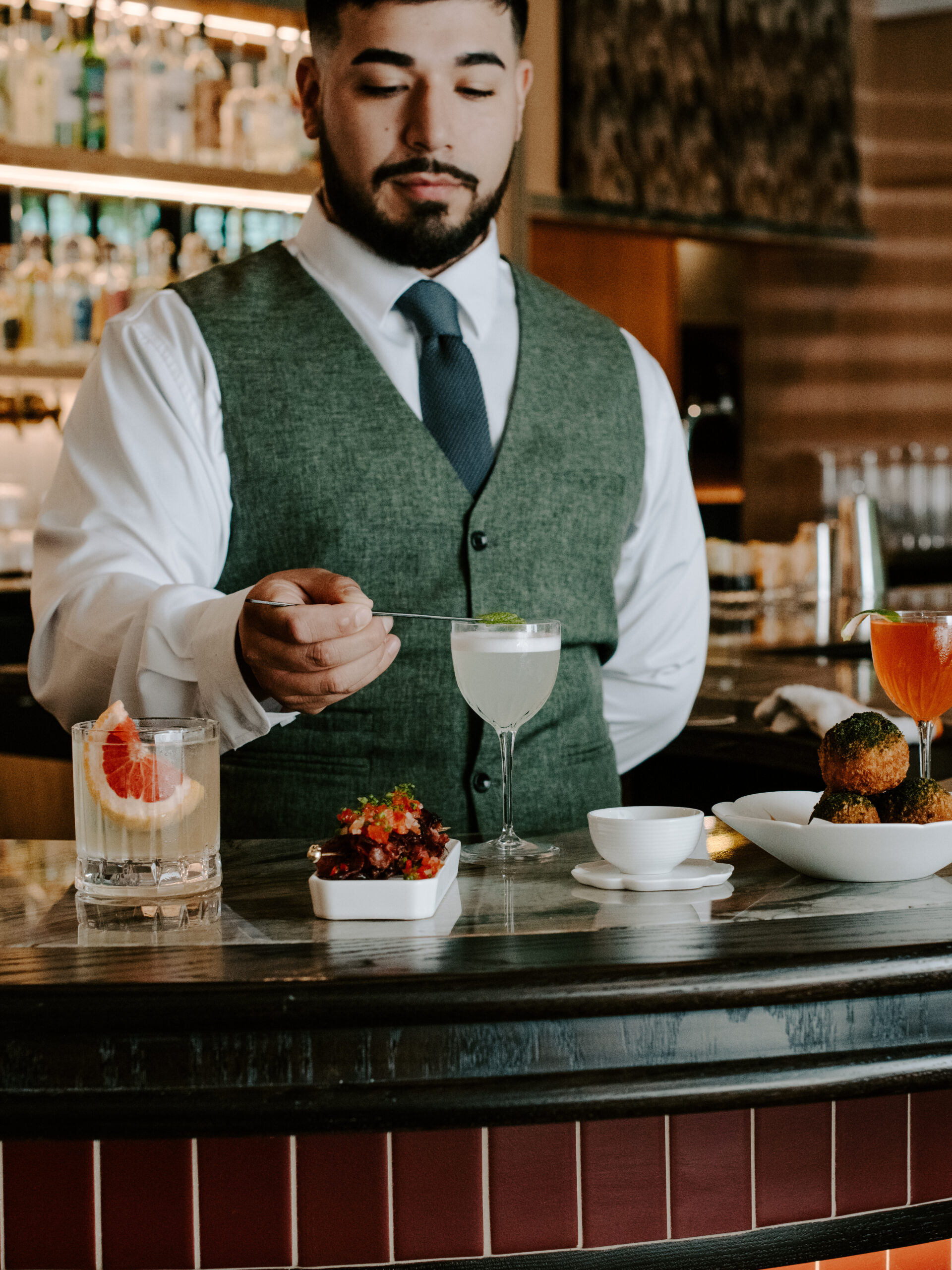Bartender serving drinks at the Nic + Junior's bar