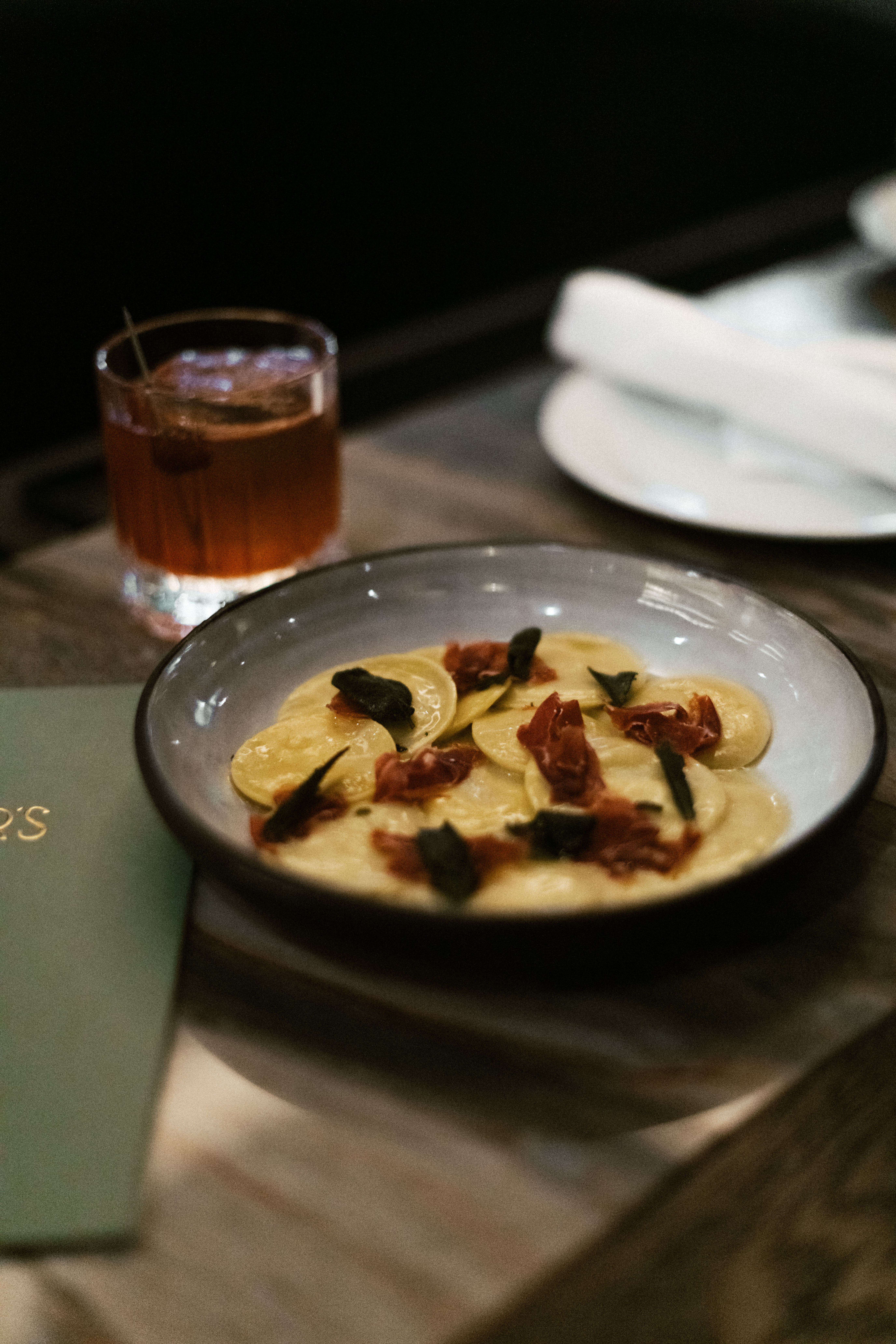 Close-up of occhi pasta at Nic + Junior’s in River North, showcasing handmade pasta filled with rich cheese and topped with seasonal garnishes.