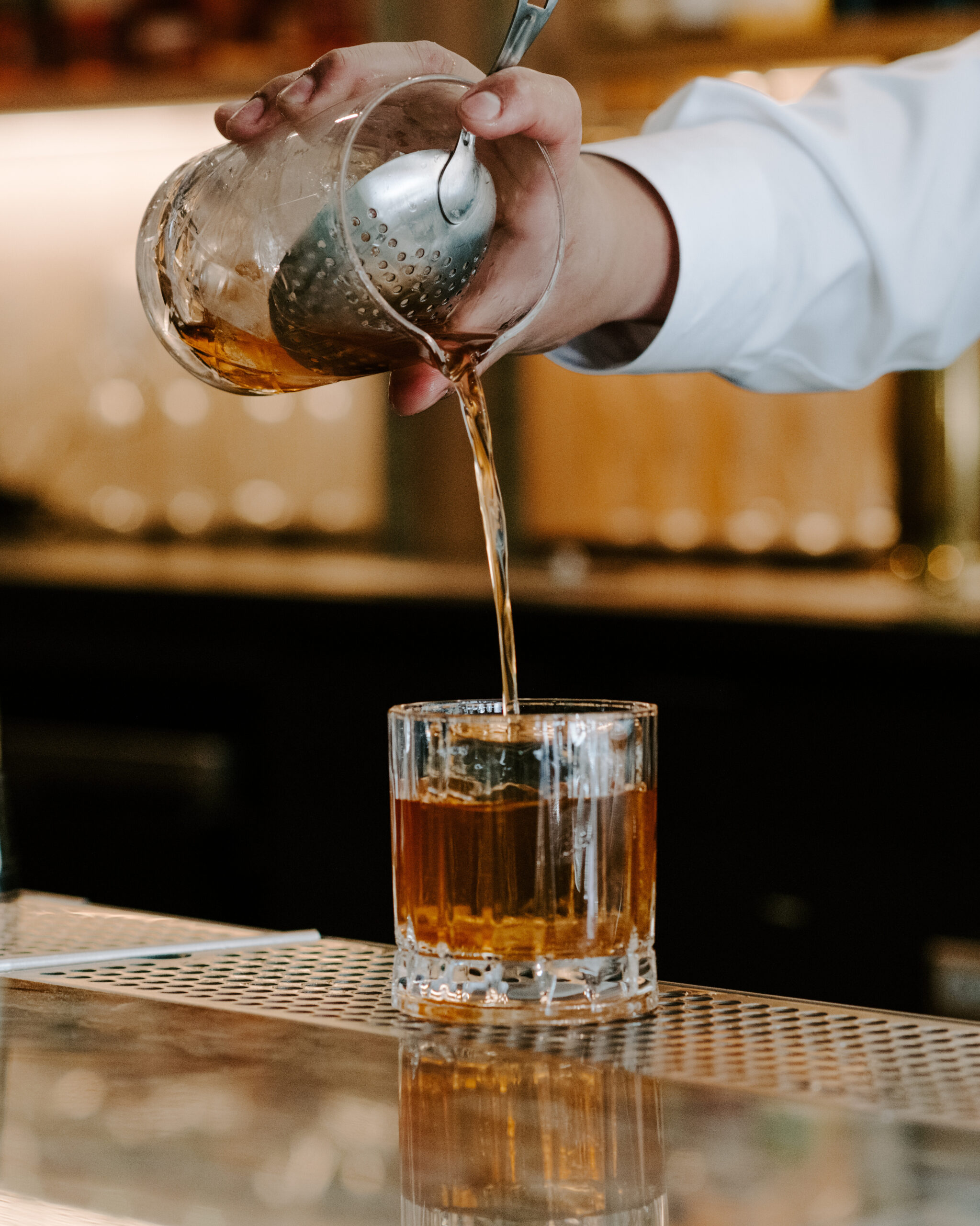 Bartender pouring an old fashioned cocktail at Nic + Junior’s in River North, Chicago