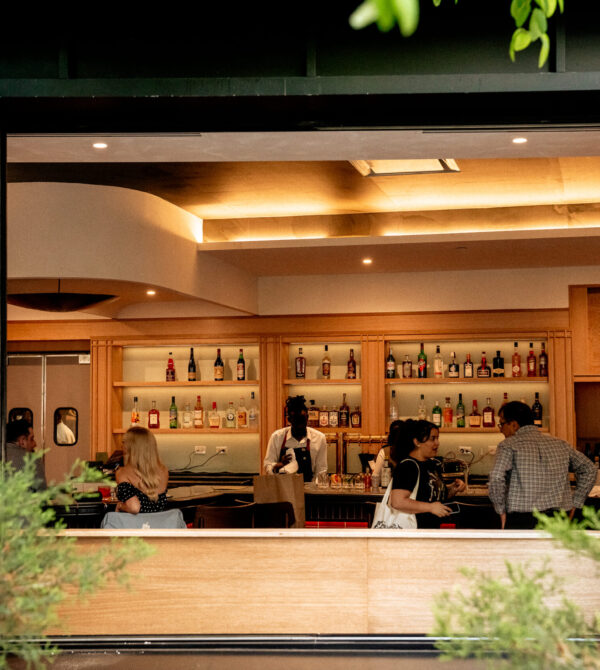 Open-air view of the bar at Nic + Junior’s in River North, Chicago, with guests and staff inside