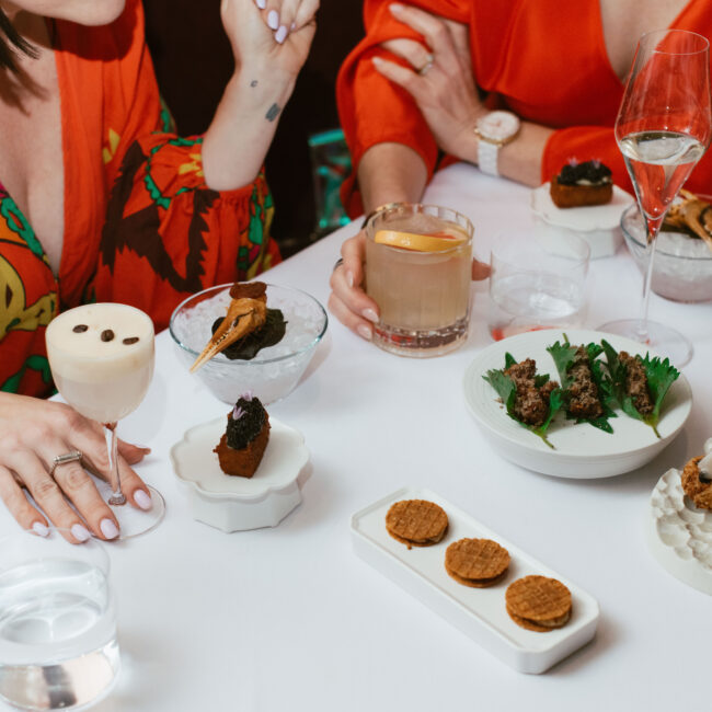 Multi-course tasting menu at Nic + Junior’s in Chicago, featuring caviar toast, crab claw on ice, and champagne service.
