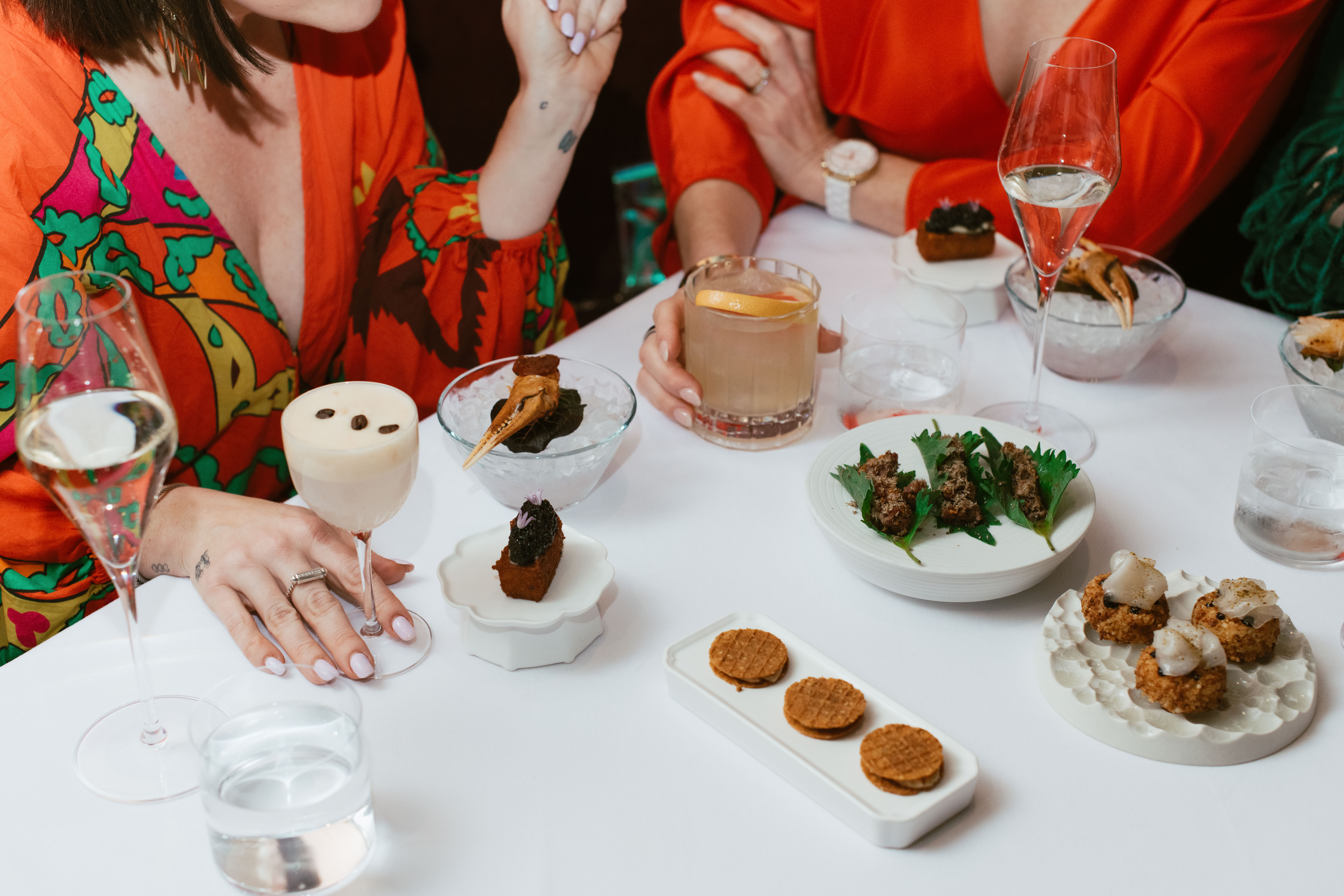 Multi-course tasting menu at Nic + Junior’s in Chicago, featuring caviar toast, crab claw on ice, and champagne service.